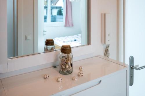 a bathroom sink with shells in a mirror at holiday with beach chair in Grömitz