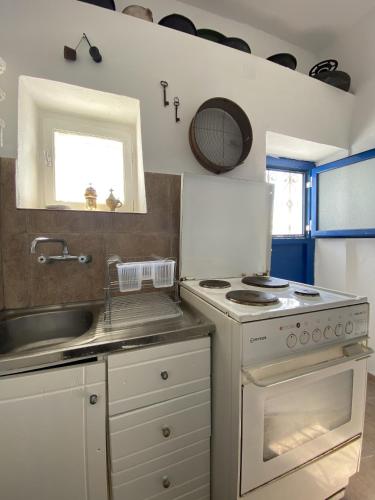 a kitchen with a sink and a stove at Sea Esta Serifos Stylish Family Home, Sea View in Serifos Chora