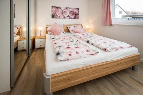 a bedroom with a large bed with pink pillows at holiday with beach chair in Grömitz