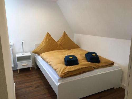 a bed with two blue bags on top of it at Berghaus 2 komfortable Wohnungen für bis zu 7 Personen - Familie - Wandern - E-Bike - Hunde - E-Ladesäule - WiFi in Schmallenberg
