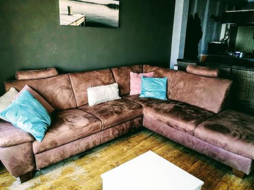 a brown leather couch in a living room at Lovely n° 9 op ieder moment een prachtig zeezicht & zwembad in Middelkerke