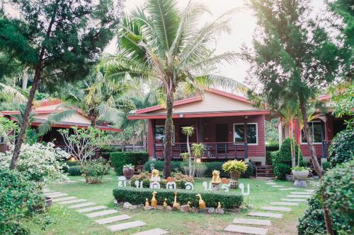 a house with a bunch of figurines in the yard at Siray Green Resort in Phuket