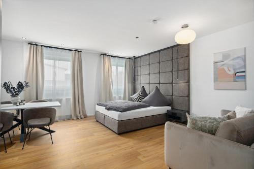フリードリヒスハーフェンにあるANYTIME - Rohrbach Apartmentsのベッドルーム1室(ベッド1台付)、リビングルームが備わります。