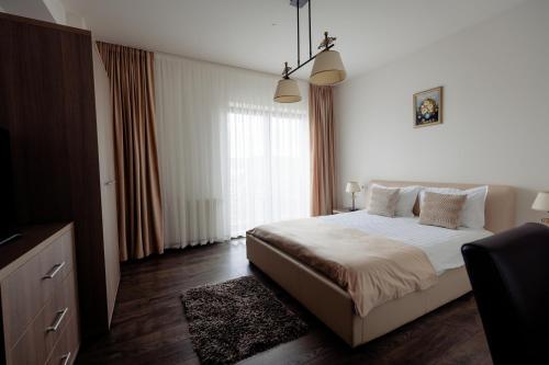 a bedroom with a bed and a large window at Aparthotel Punct pe i in Sighetu Marmaţiei