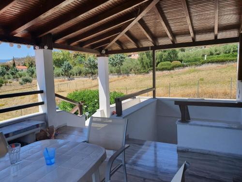 a patio with a table and chairs and a view of a field at Haus Regina in Khronia