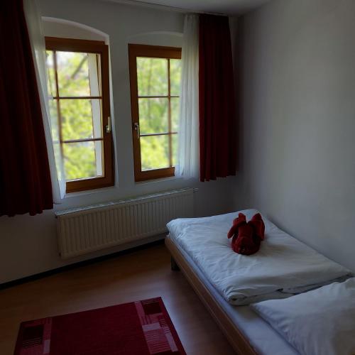 a room with a bed with a stuffed animal on it at Picobello Pension in Görlitz