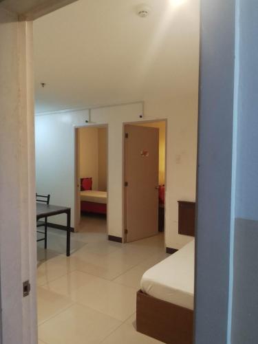 una camera con un letto, un tavolo e una porta di WJV INN LAHUG a Cebu City