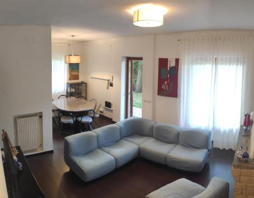 uma sala de estar com um sofá azul e uma mesa em Casa vacanze Il Parco em Manziana