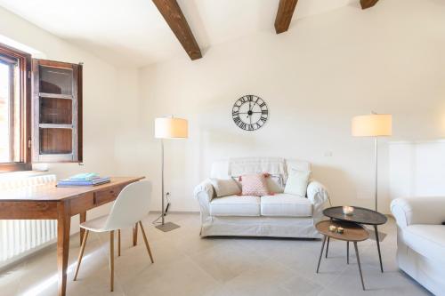 a living room with a white couch and a table at Albergo Diffuso Borgo Santo in Asciano