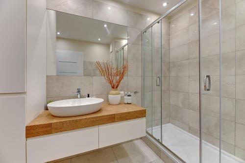a bathroom with a sink and a shower at Downtown Apartments Seaside Awiator in Gdańsk