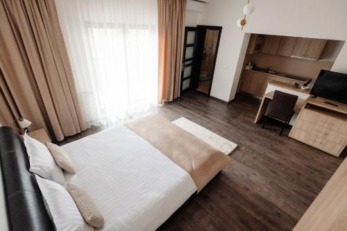 a bedroom with a large bed and a kitchen at Aparthotel Punct pe i in Sighetu Marmaţiei