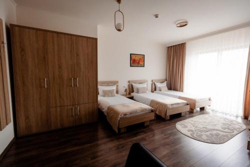 a bedroom with two beds and a cabinet at Aparthotel Punct pe i in Sighetu Marmaţiei