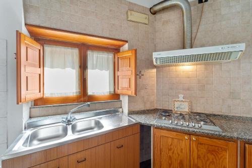 uma cozinha com um lavatório e um fogão em Villa Mariuccia em Dolianova