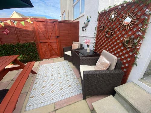 a patio with a gate and chairs and a table at The Garden Flat at Wynncroft in Paignton