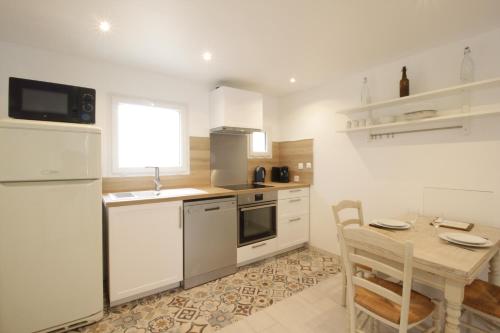 een keuken met een tafel en een witte koelkast bij Le Petit Canivet ultra cosy in Cerny