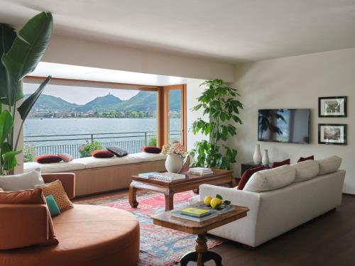 a living room with couches and a view of the water at Hotel Villa Flori in Como