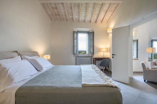 a bedroom with a large bed and a desk at Albergo Diffuso Borgo Santo in Asciano