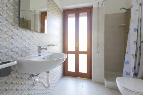 y baño con lavabo, aseo y espejo. en Visitsicilia Rosetta Mare, en Alcamo Marina