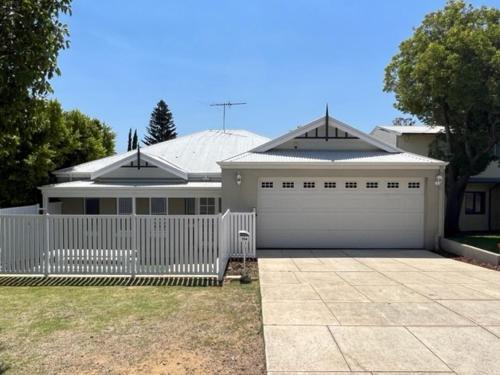 a white fence in front of a white garage at Beachy Vibes in Karrinyup in Perth