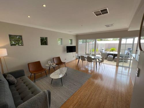 - un salon avec un canapé et une table dans l'établissement Beachy Vibes in Karrinyup, à Perth