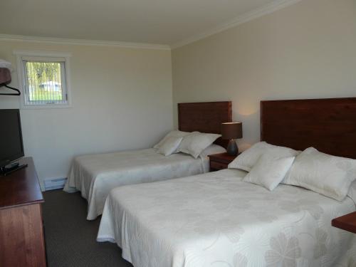 Кровать или кровати в номере Motel & Chalets Baie de Gaspé