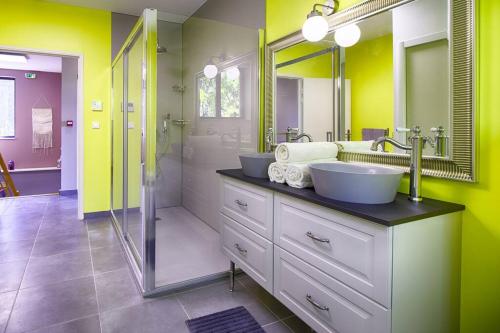 ein Bad mit 2 Waschbecken und einer Dusche in der Unterkunft La maison des Eucalyptus - Piscine, jacuzzis et lac in Orange
