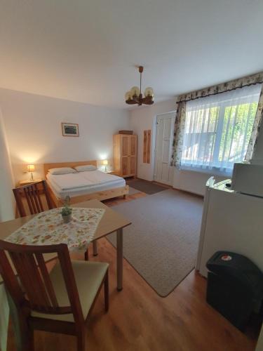 a living room with a bed and a table and a room with a tablektop at Casa Anette in Sovata