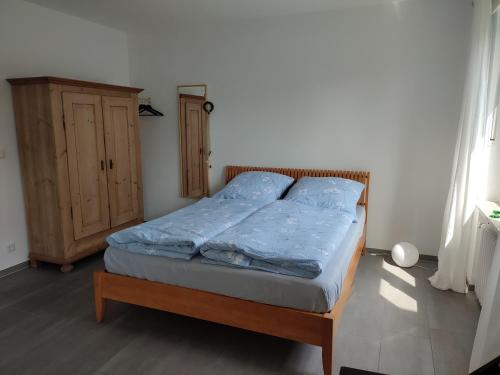 a bedroom with a bed with blue sheets and a cabinet at Van´s Zimmerglück in Borken