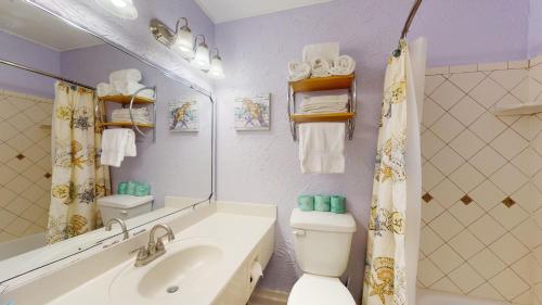 y baño con lavabo, aseo y espejo. en Villas by The Sea Resort by Jekyll Realty, en Jekyll Island