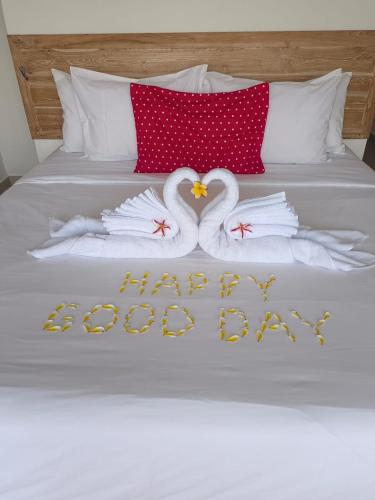two swans are making a happy anniversary on a bed at Utama Villas Beach Front Candidasa in Candidasa
