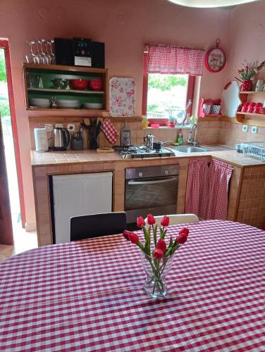 a kitchen with a table with a vase of flowers on it at Apartments Popaj in Komiža