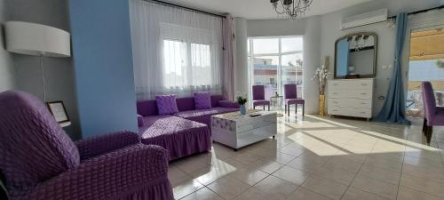 salon z fioletowymi meblami i fioletowymi krzesłami w obiekcie Mary's Apartment w mieście Kos