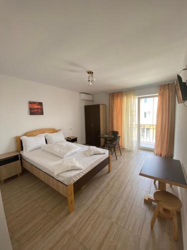 a bedroom with a large bed and a table at Kherim 2 in Tuzla
