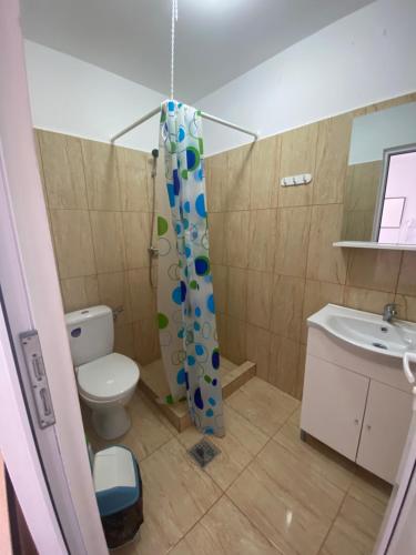 a bathroom with a toilet and a shower curtain at Kherim 2 in Tuzla