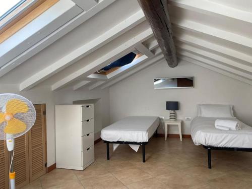 a attic room with two beds and a desk at Paganini29 - Elegante appartamento vicino all'autodromo Monza in Monza