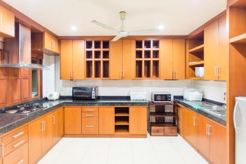 a kitchen with wooden cabinets and a ceiling fan at Siray Green Resort in Phuket