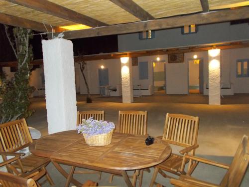 a wooden table with chairs and a basket of flowers on it at ΠΑΡΑΘΙΝ ΑΛΟΣ 2 in Skiros