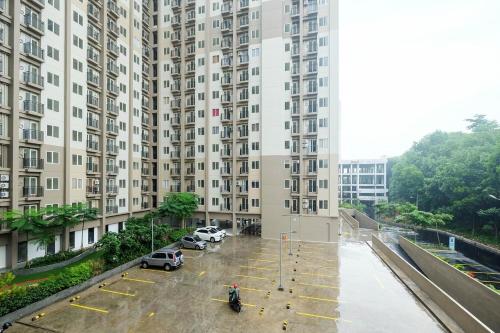 a large building with cars parked in a parking lot at Room Rendi Podomoro Golf View in Taladjurg-udik