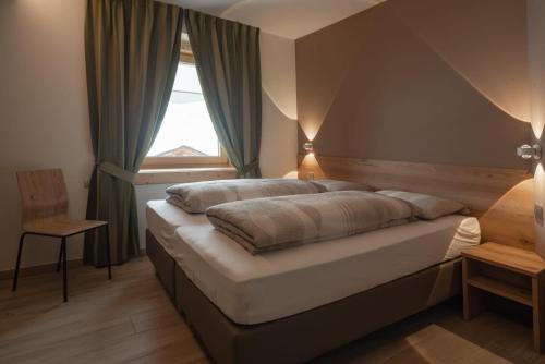 a bedroom with a large bed with a window at Bait Martin Appartamento 3 in Livigno