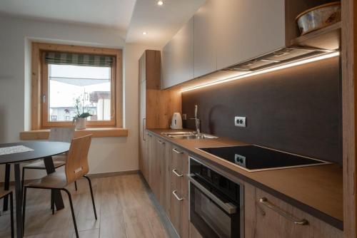 a kitchen with a sink and a table with a dining room at Bait Martin Appartamento 3 in Livigno