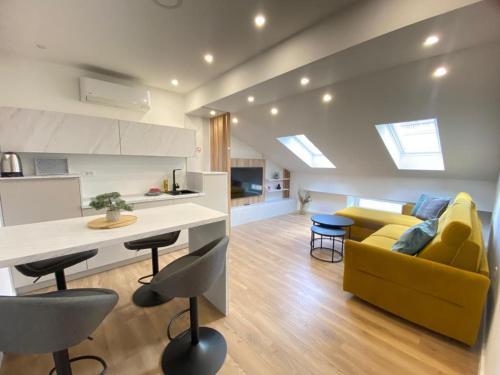 a living room with a yellow couch and a kitchen at Lux City Apartments & Rooms in Sarajevo
