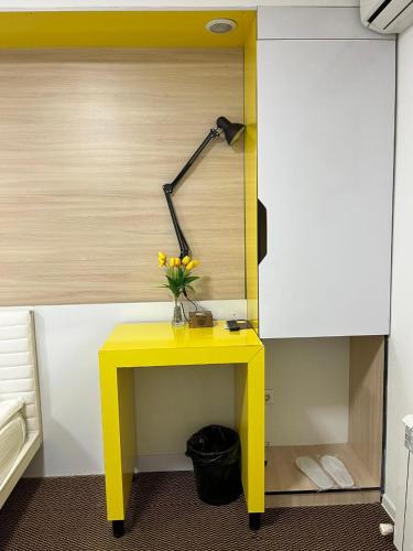 a yellow table with a vase of flowers on it at iO Boutique Hotel Bishkek in Bishkek