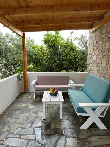 eine Terrasse mit 2 Stühlen, einem Tisch und einem Sofa in der Unterkunft Elia Home in Lefkogeia