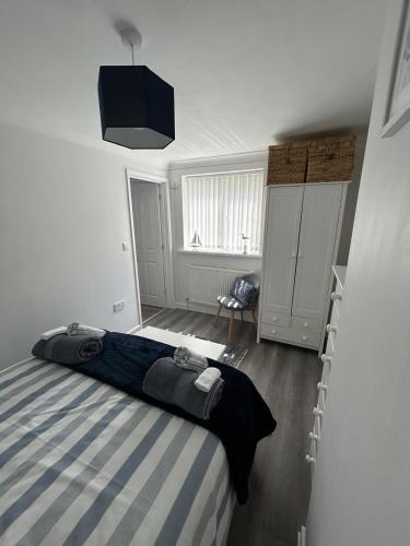 a bedroom with a bed with a blue and white stripes at Ruby's Den in Carbis Bay