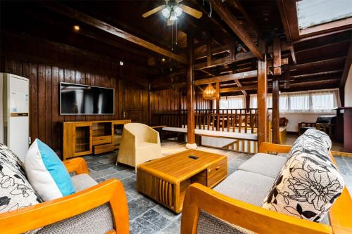 a living room with a couch and a tv at SecGarden Boutique Hotel in Zhangjiajie