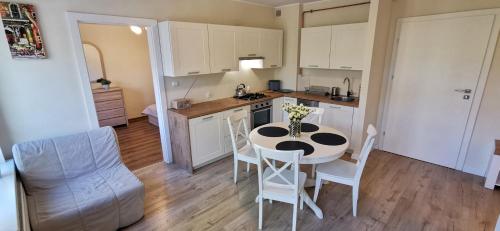 - une cuisine avec une table et des chaises dans la chambre dans l'établissement Najs Apartamenty z parkingiem, à Sopot