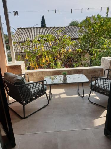 a patio with two chairs and a table on a balcony at Angels Pool Studios and Apartments in Paleokastritsa