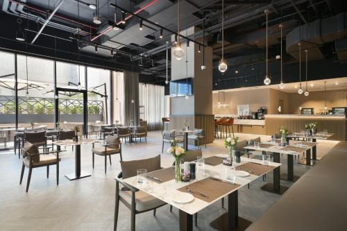 a dining room with tables and chairs and windows at Cheval Maison - The Palm in Dubai