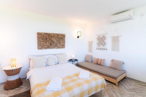 Habitación blanca con cama y sofá en Rezident Corbu, en Corbu