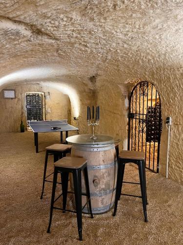 a wine tasting room with a barrel and two stools at A l'Ombre d'Azay - Demeure d'Hôtes - GuestHouse in Azay-le-Rideau